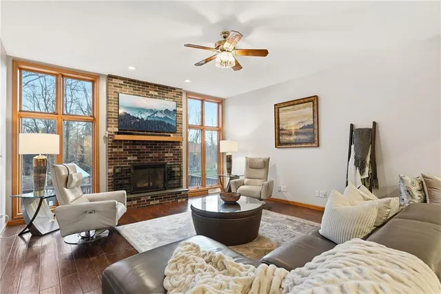 a living room with furniture a fireplace and a large window