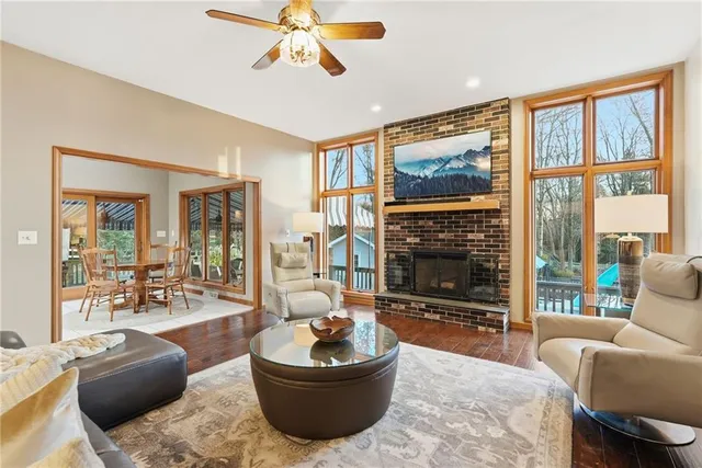 a living room with furniture a flat screen tv and a large window
