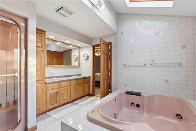 a bathroom with a tub sink and mirror