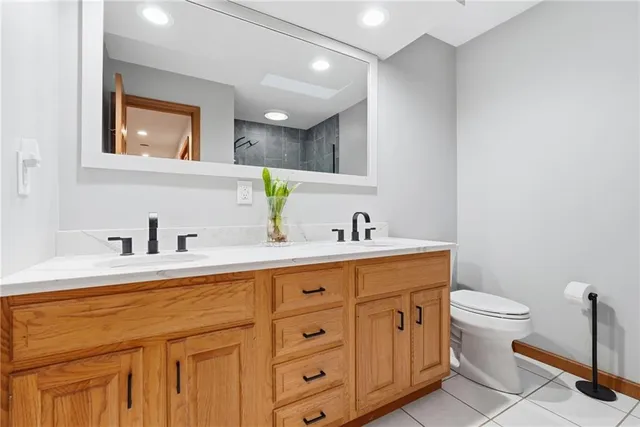 a spacious bathroom with a toilet sink and mirror