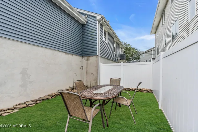 a backyard of a house with table and chairs
