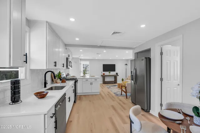 a large kitchen with kitchen island a stove a sink a dining table and chairs