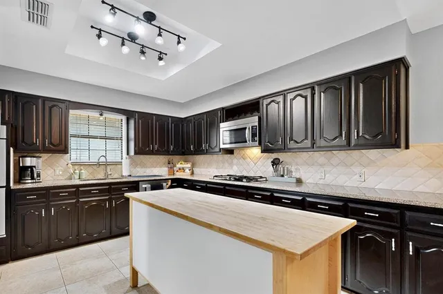 a kitchen with kitchen island granite countertop cabinets and stainless steel appliances