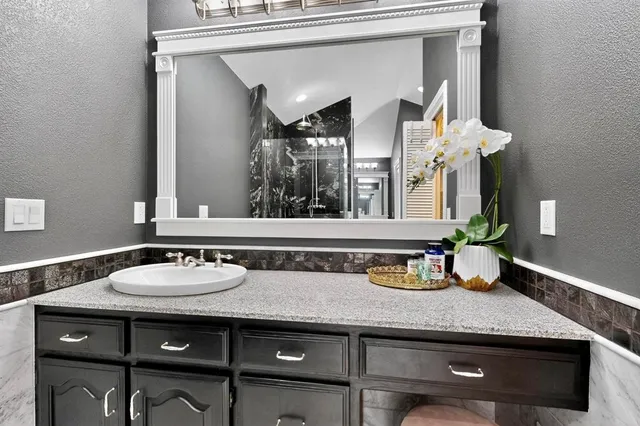 a bathroom with a granite countertop sink and a mirror