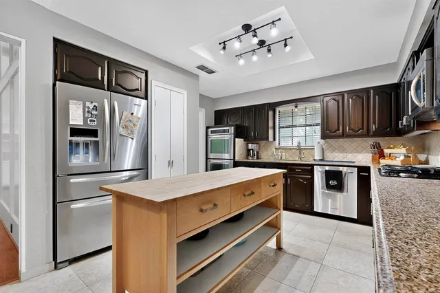 a kitchen with stainless steel appliances granite countertop a stove and cabinets