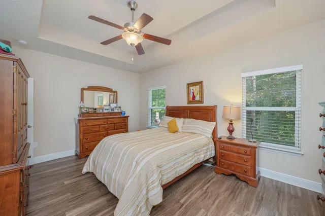 a bedroom with a bed next to a window with a chandelier