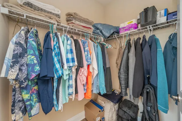 a view of walk in closet with clothes and shoes