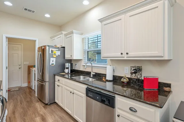 a kitchen with stainless steel appliances granite countertop a refrigerator sink and cabinets