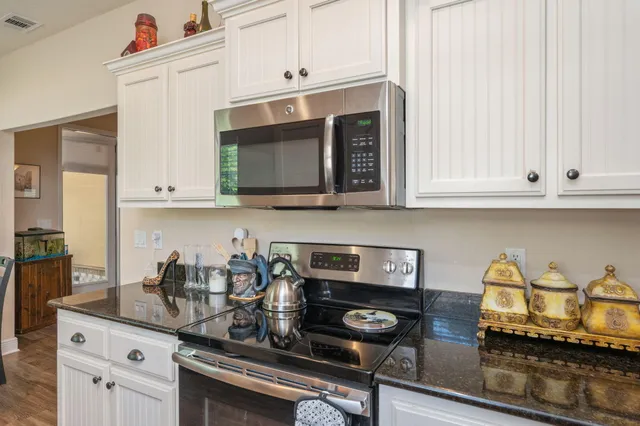 a kitchen with appliances a stove and cabinets
