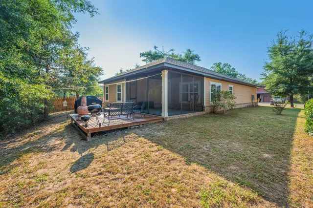 a view of a house with backyard and sitting area