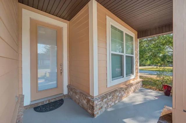 a view of a room that has a large window and front door