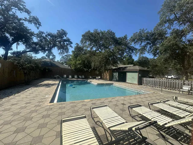 a view of a tennis ground with large trees