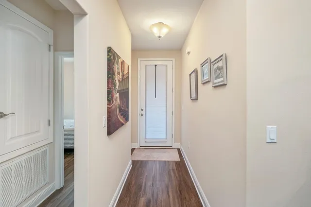 a view of a hallway with wooden floor and staircase