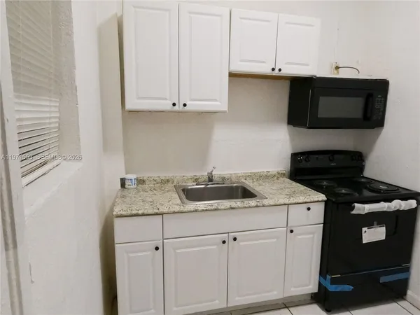 a kitchen with stainless steel appliances granite countertop white cabinets and a stove