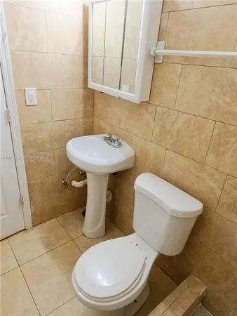 a white toilet sitting next to a bathroom sink