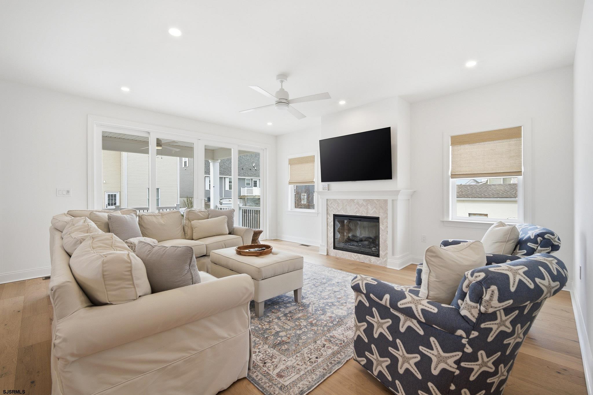150 South 9th Brigantine, NJ 08203 - Photo 11 of 32 a living room with furniture a fireplace and a flat screen tv