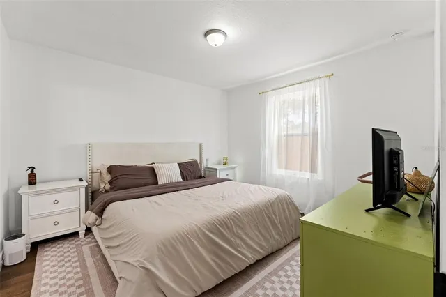 a bedroom with a bed and a computer on the table