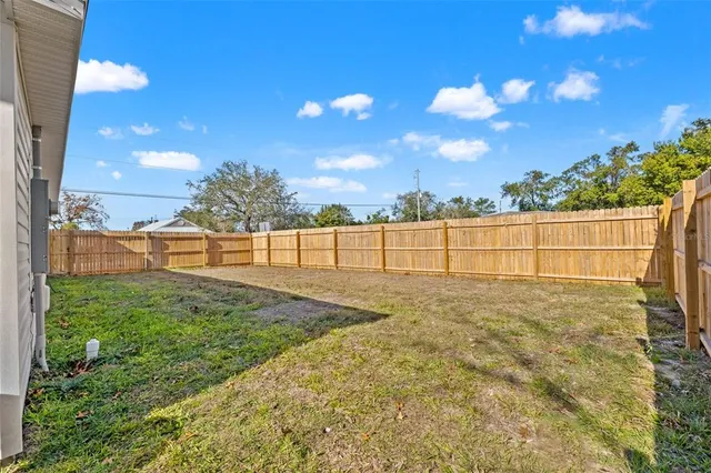 a view of yard with wooden fence