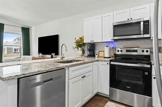 a kitchen with stainless steel appliances granite countertop a stove microwave and sink