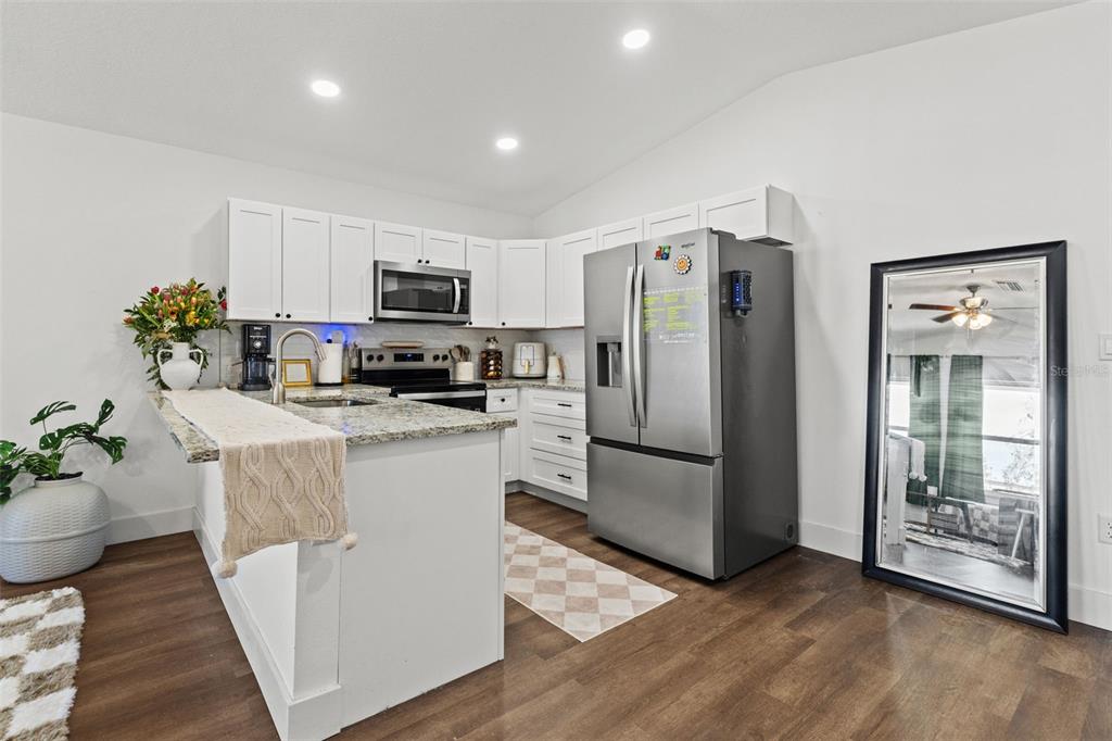 3592 Arrowhead Avenue Spring Hill, FL 34606 - Photo 8 of 22 a kitchen with kitchen island a counter top space a refrigerator and a stove