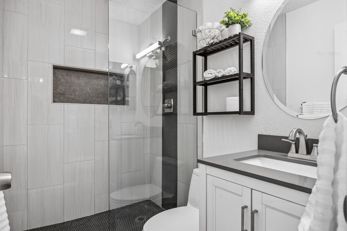 6308 Shadow Bend Austin, TX 78745 - Photo 13 of 35 a bathroom with a toilet sink and mirror