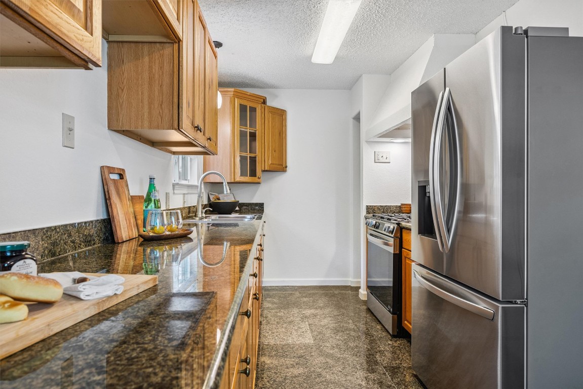 6308 Shadow Bend Austin, TX 78745 - Photo 7 of 35 a kitchen with stainless steel appliances granite countertop a refrigerator a stove and a sink