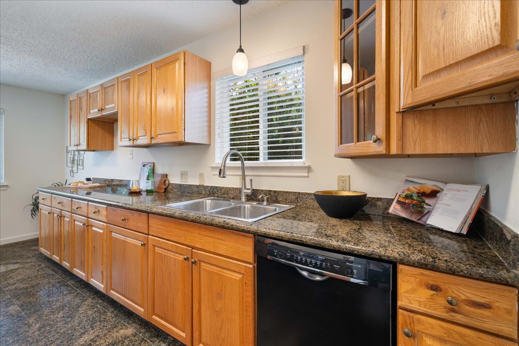 6308 Shadow Bend Austin, TX 78745 - Photo 9 of 35 a kitchen with granite countertop a sink a stove and cabinets