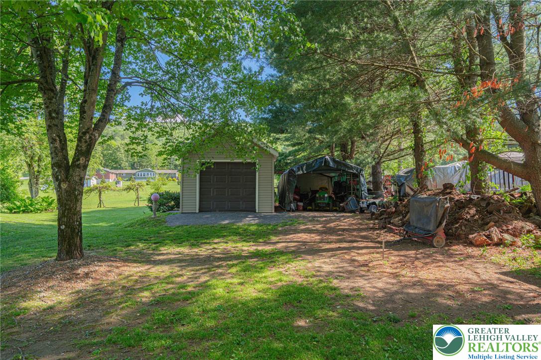 341 Lower Greenhill Road Kunkletown, PA 18058 - Photo 65 of 69 A detached garage offers ample storage space, surrounded by mature trees providing natural shade.