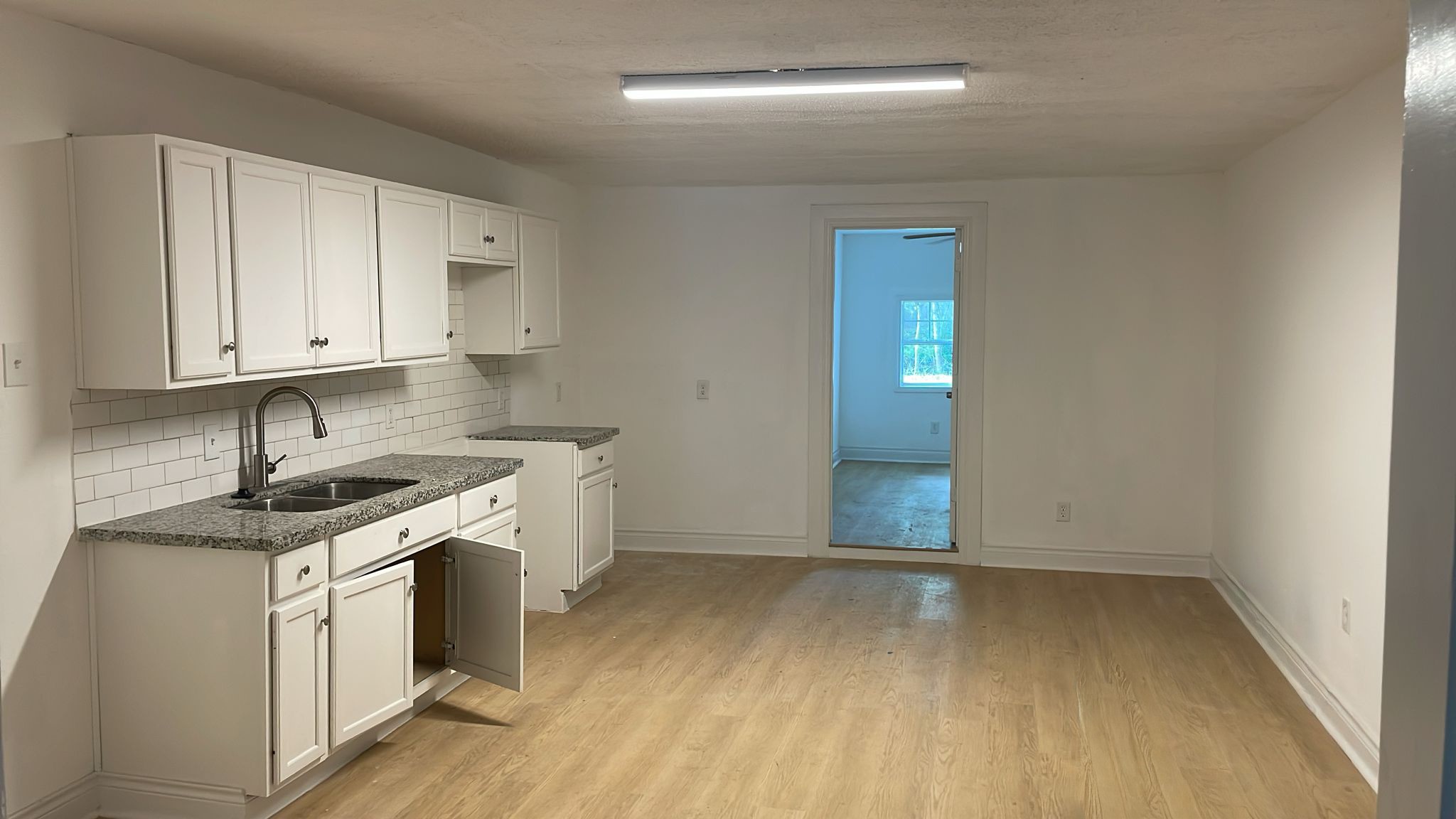 3518 Schurmier Road, Unit A Houston, TX 77047 - Photo 3 of 12 an empty room with wooden floor and cabinets