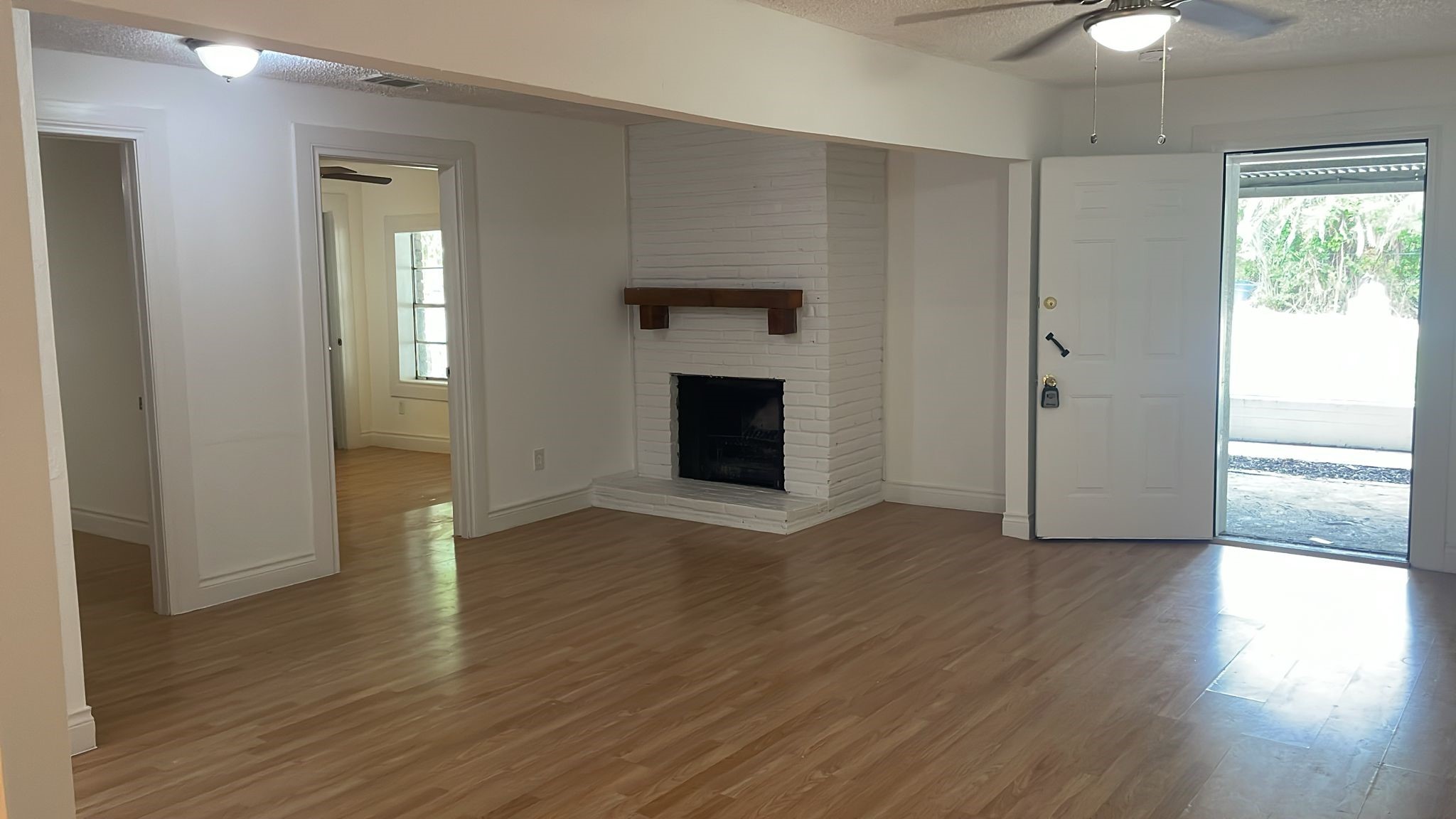 3518 Schurmier Road, Unit A Houston, TX 77047 - Photo 8 of 12 an empty room with wooden floor fireplace and windows
