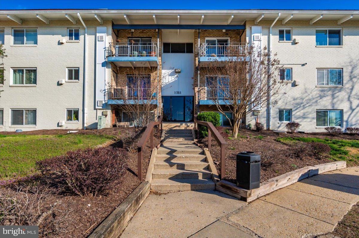 a front view of a residential apartment building with a yard