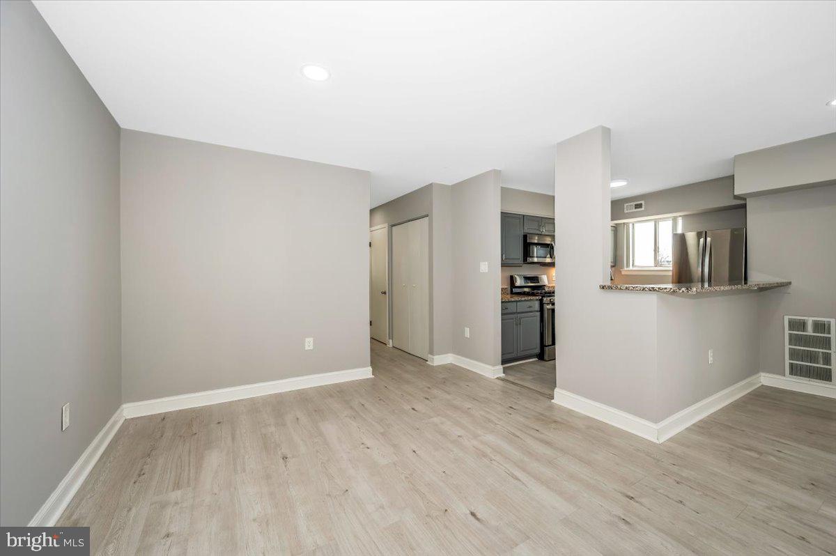 11368 Cherry Hill Road, Unit 1Q204 Beltsville, MD 20705 - Photo 14 of 46 a view of a kitchen with wooden floor and a refrigerator