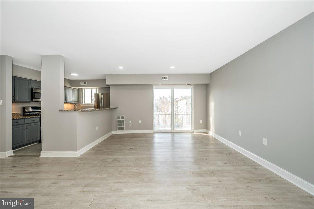 11368 Cherry Hill Road, Unit 1Q204 Beltsville, MD 20705 - Photo 18 of 46 a view of an empty room with kitchen and window