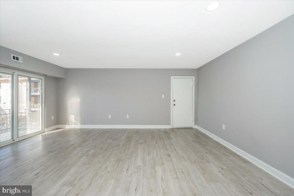 11368 Cherry Hill Road, Unit 1Q204 Beltsville, MD 20705 - Photo 19 of 46 a view of an empty room with wooden floor and a window
