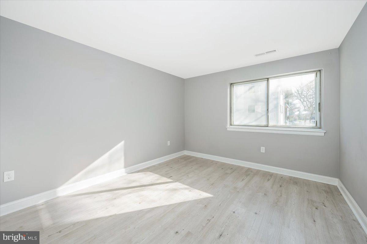 11368 Cherry Hill Road, Unit 1Q204 Beltsville, MD 20705 - Photo 21 of 46 an empty room with wooden floor and windows