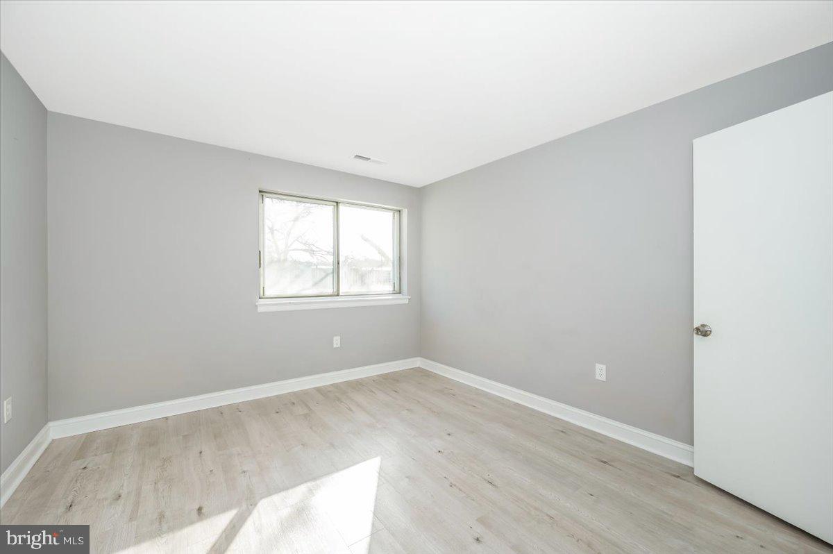 11368 Cherry Hill Road, Unit 1Q204 Beltsville, MD 20705 - Photo 22 of 46 an empty room with wooden floor and windows
