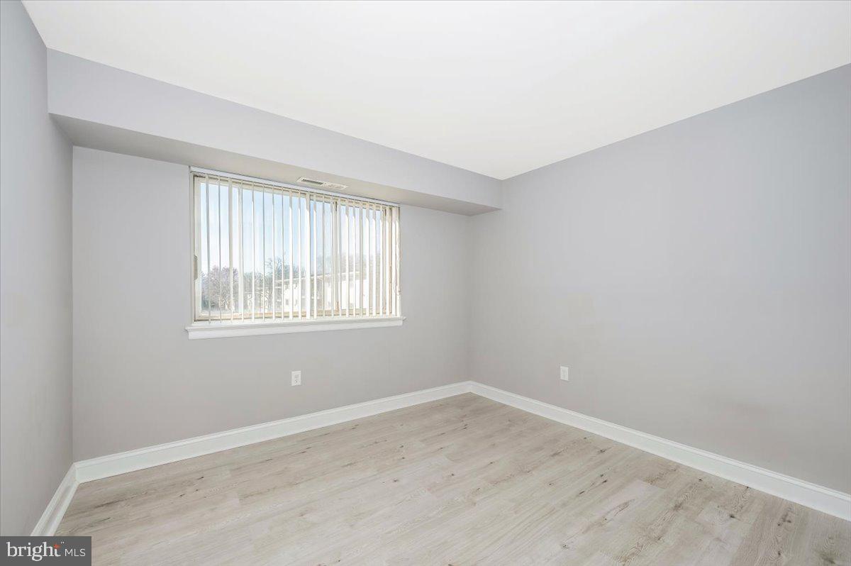 11368 Cherry Hill Road, Unit 1Q204 Beltsville, MD 20705 - Photo 28 of 46 an empty room with wooden floor and windows