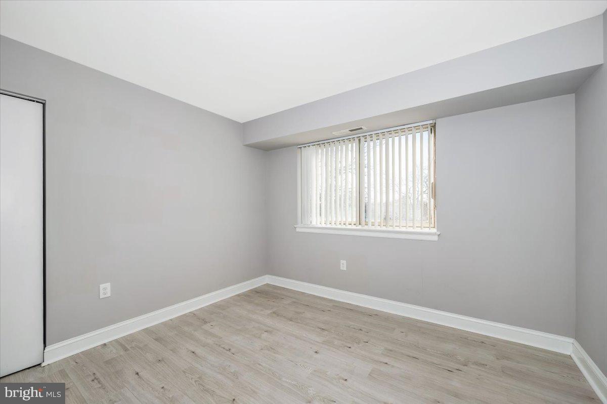 11368 Cherry Hill Road, Unit 1Q204 Beltsville, MD 20705 - Photo 29 of 46 an empty room with wooden floor and windows