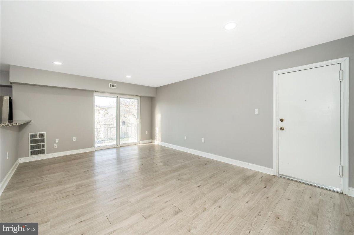 11368 Cherry Hill Road, Unit 1Q204 Beltsville, MD 20705 - Photo 35 of 46 a view of an empty room with wooden floor and a window