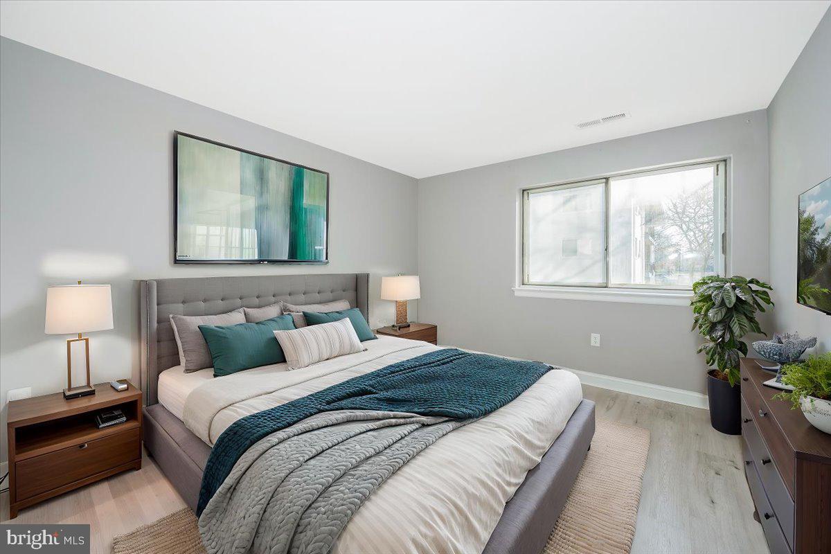 11368 Cherry Hill Road, Unit 1Q204 Beltsville, MD 20705 - Photo 4 of 46 a bedroom with a bed and a potted plant