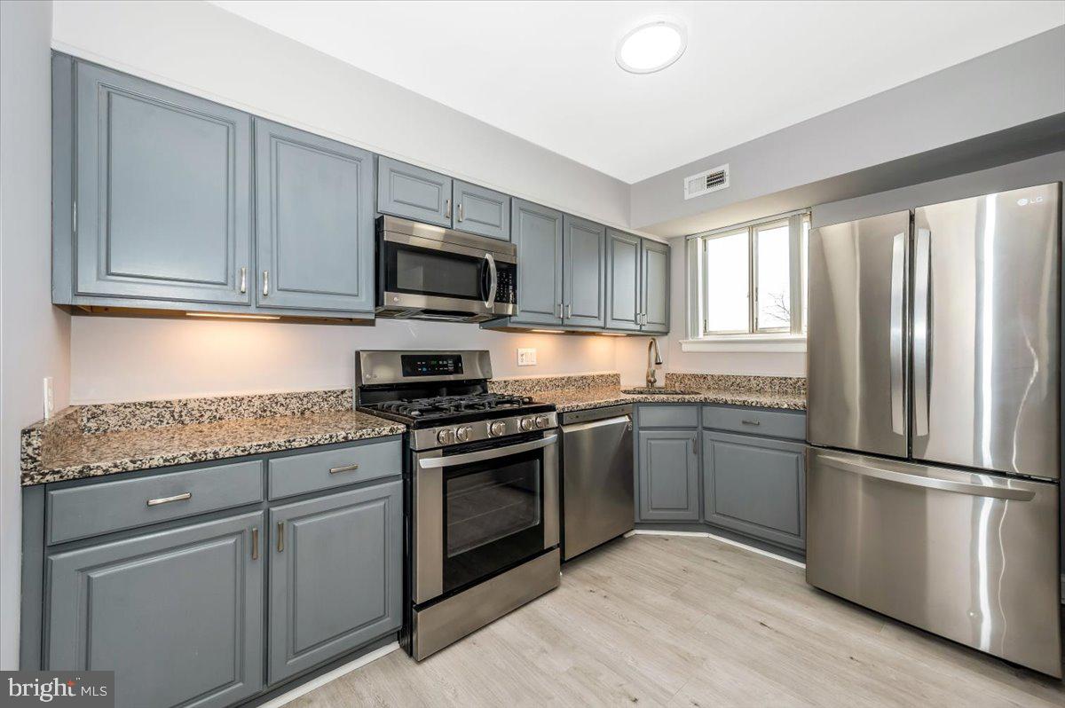 11368 Cherry Hill Road, Unit 1Q204 Beltsville, MD 20705 - Photo 6 of 46 a kitchen with granite countertop a refrigerator stove top oven and sink
