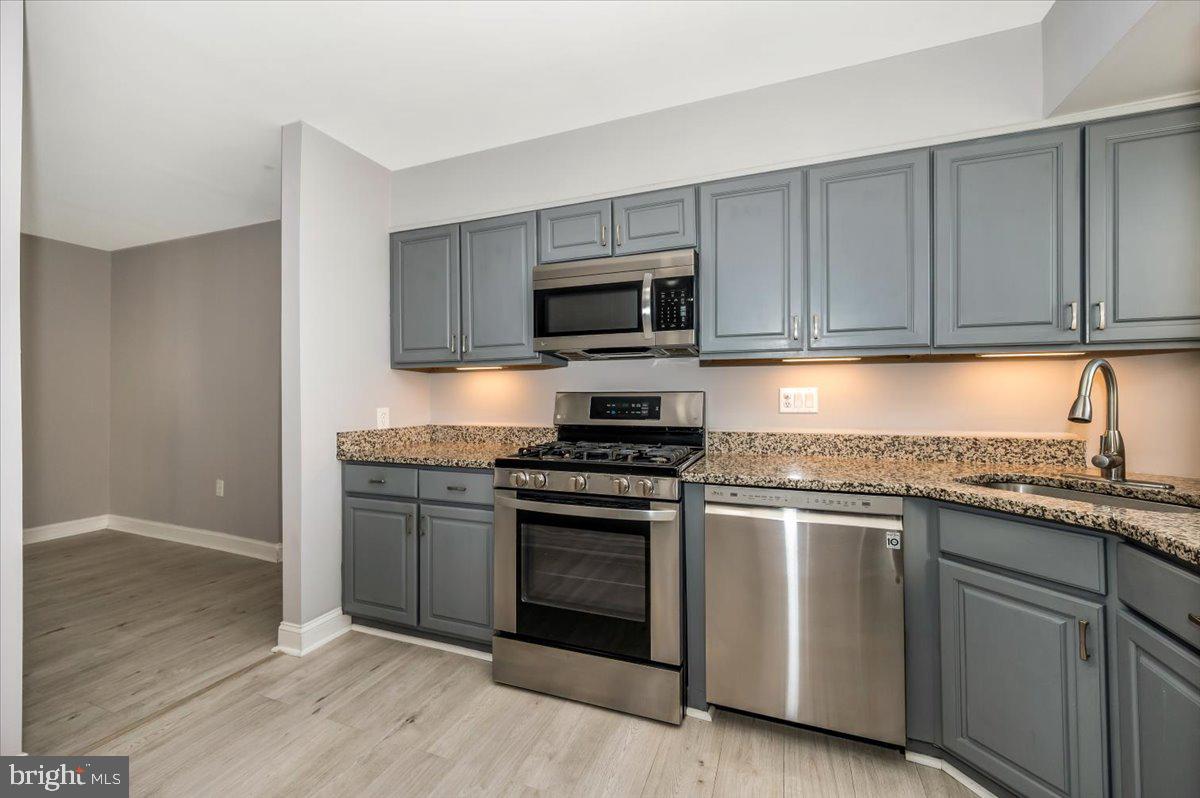 11368 Cherry Hill Road, Unit 1Q204 Beltsville, MD 20705 - Photo 9 of 46 a kitchen with granite countertop cabinets stainless steel appliances and wooden floor