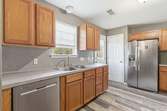 a kitchen with stainless steel appliances granite countertop a refrigerator and a sink
