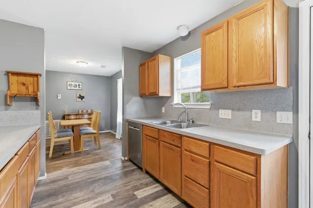 a kitchen with stainless steel appliances granite countertop sink stove and wooden cabinets