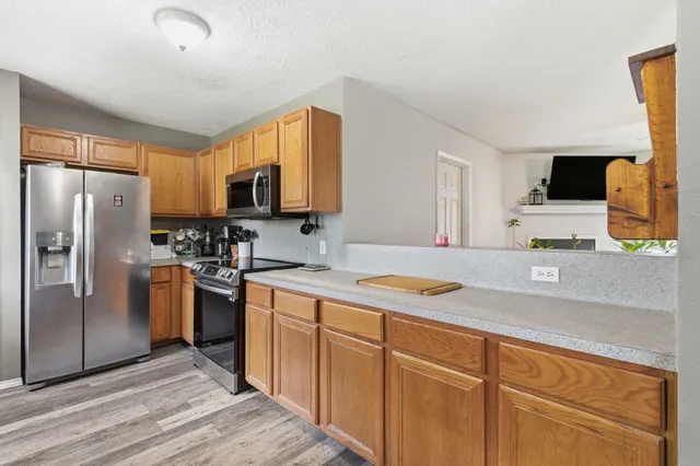 a kitchen with stainless steel appliances granite countertop a refrigerator sink and microwave
