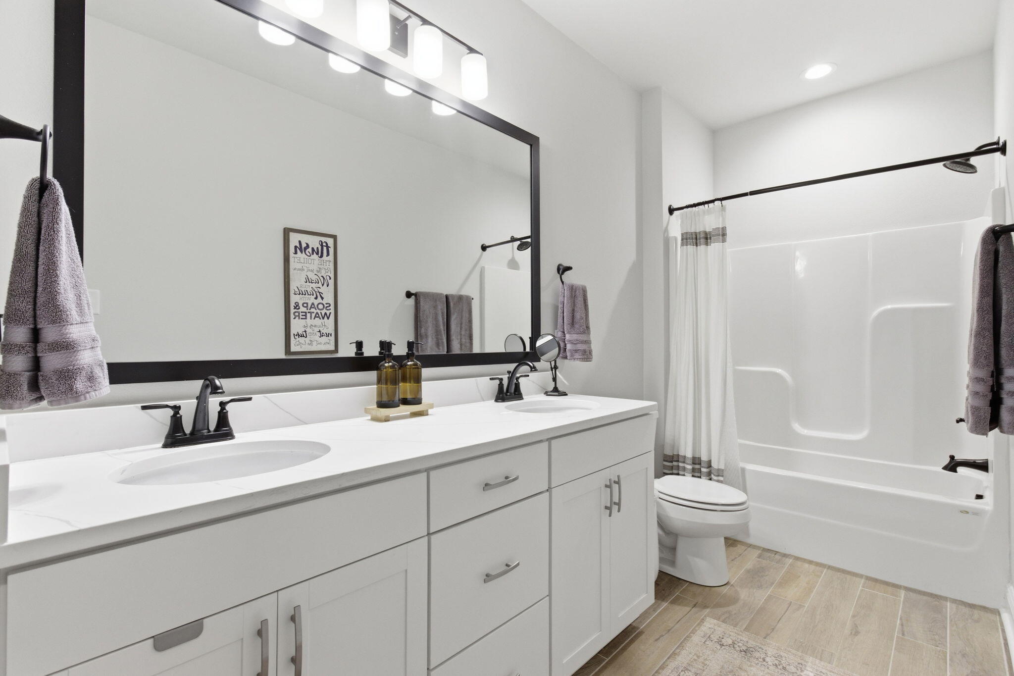 140 Flora Lane Freeport, FL 32439 - Photo 20 of 77 a bathroom with a double vanity sink a toilet mirror and bathtub
