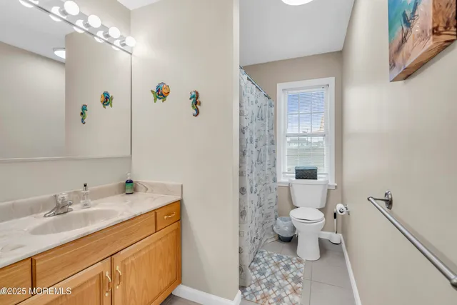 a bathroom with a sink a toilet a large mirror and shower