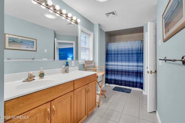 a bathroom with a sink a toilet a large mirror and shower