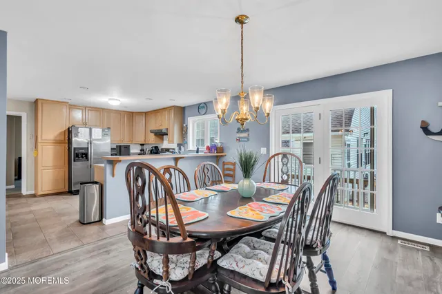 a kitchen with stainless steel appliances granite countertop a stove a sink a refrigerator a kitchen island with a dining table and chairs