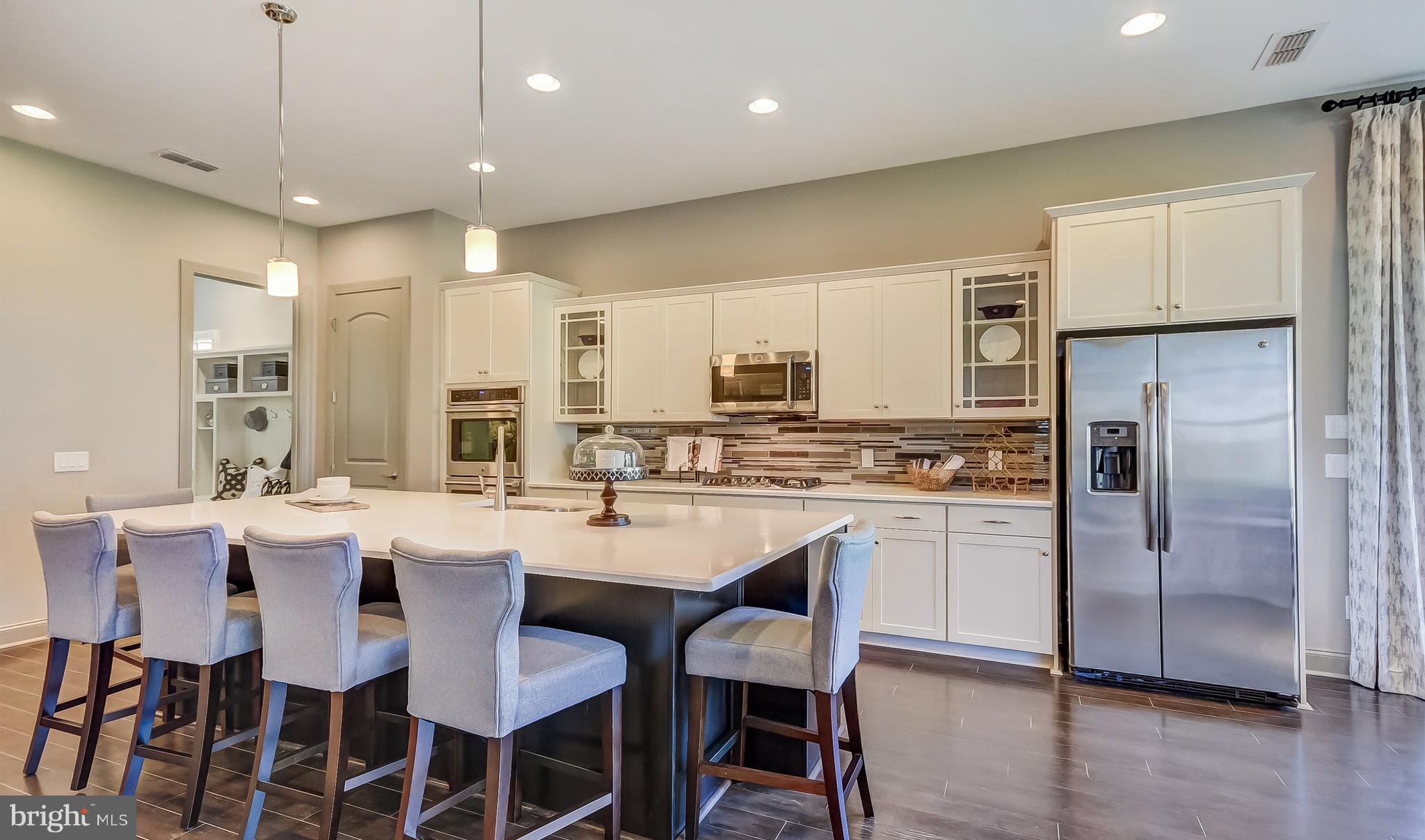 19150 Chartres Street Lewes, DE 19958 - Photo 4 of 12 a kitchen with stainless steel appliances kitchen island granite countertop a dining table chairs stove refrigerator and cabinets